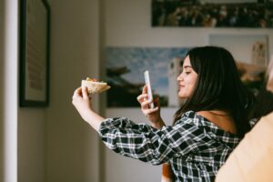 Woman taking picture of food with cellphone